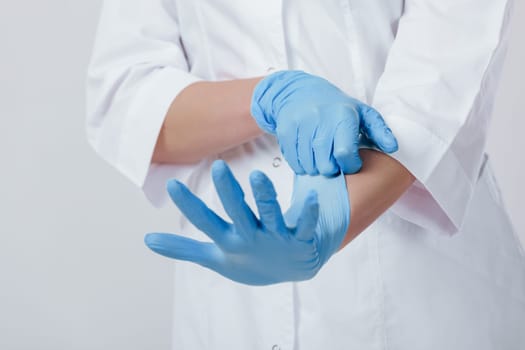 Woman doctor hands wears medical latex blue gloves, close-up