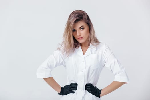 Portrait of glamor female professional cosmetologist in black gloves. Woman beautician doctor in studio