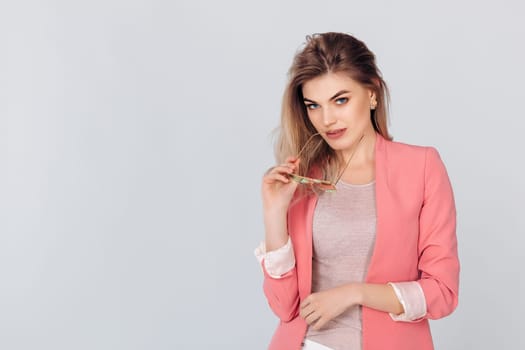 Fashion portrait of attractive elegant blonde woman in pastel casual pink jacket posing in studio. woman dressed in trendy spring outfit