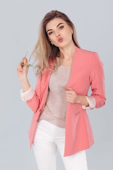 Fashion portrait of attractive elegant blonde woman in pastel casual pink jacket posing in studio. woman dressed in trendy spring outfit