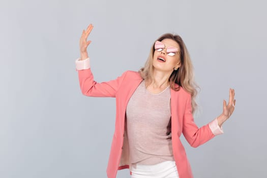 Fashion portrait of attractive elegant blonde woman in pastel jacket and sunglasses dancing. woman dressed in trendy spring outfit