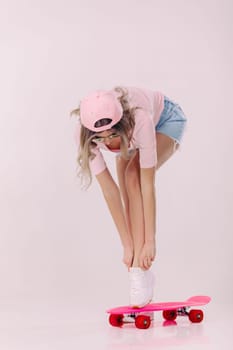 beautiful woman in sunglasses, pink t-shirt and cap with pink skateboard