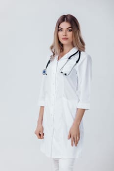 Medical physician doctor woman in white coat with stethoscope on light background.
