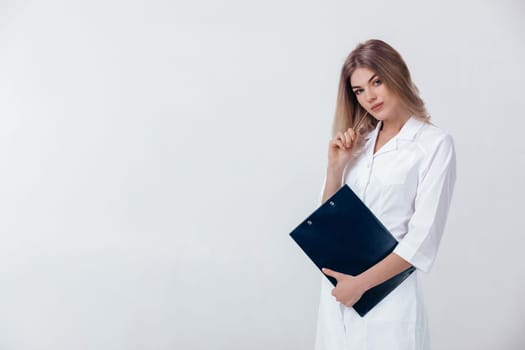 Medical physician doctor woman in white coat holds folder with documents on light background.