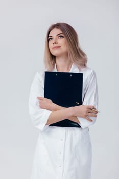 happy medical physician doctor woman in white coat holds folder with documents on light background.