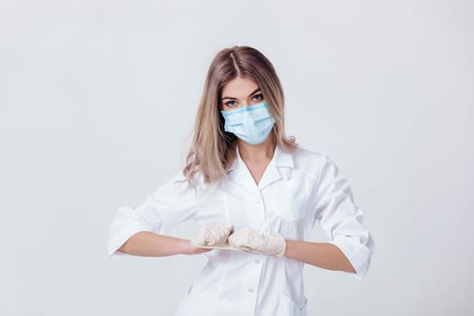 Portrait of woman doctor with face mask wearing white medical gloves