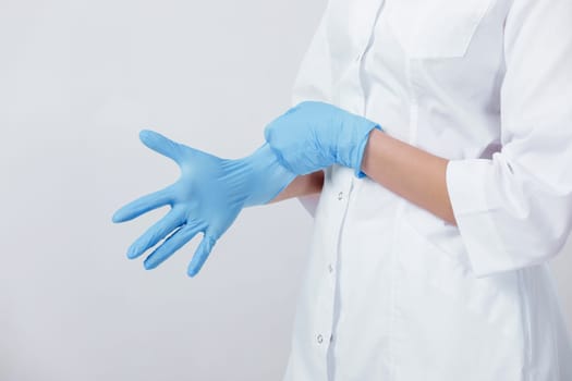 Woman doctor hands wears medical latex blue gloves, close-up