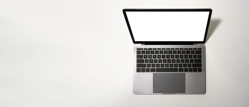 A laptop computer with blank display on white background. Flat lay, top view with copy space.