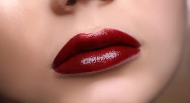 Closeup of beautiful female lips with red lipstick. Professional makeup concept