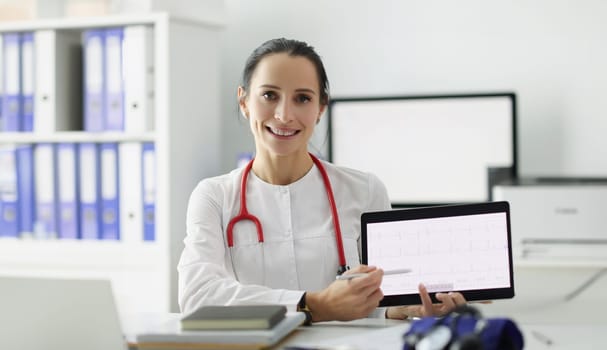 Doctor cardiologist showing electrocardiogram on digital tablet. ECG decoding concept training course