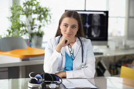 Portrait of woman doctor with glasses in her hands in clinic office. Medical consulting concept