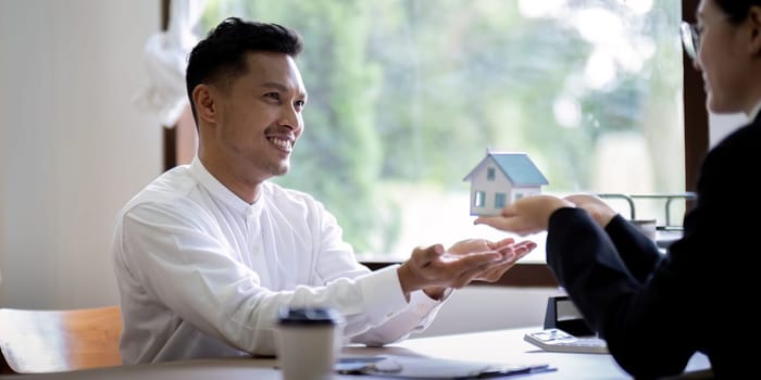 Customer meet and negotiation with real estate agents about renting, buying home, Real estate agent negotiate, talk about the terms of the home purchase agreement and asked customer to sign contract.