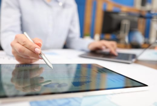 Female hand studying information on digital tablet with stylus closeup. Management concept