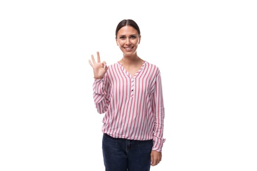 a young smiling European woman with black hair gathered in a ponytail is dressed in a red and white striped blouse.