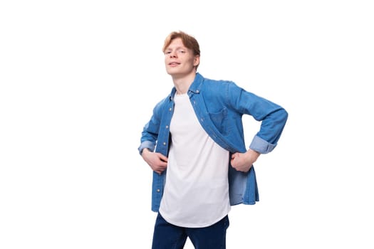 portrait of a confident caucasian red-haired guy in a denim blue shirt and a white t-shirt with a mockup for advertising.
