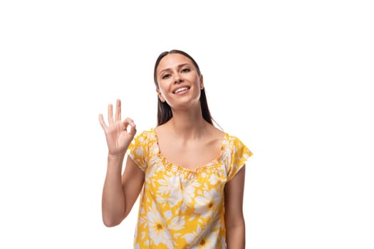 young pretty brunette woman dressed in a summer yellow t-shirt on a white background.