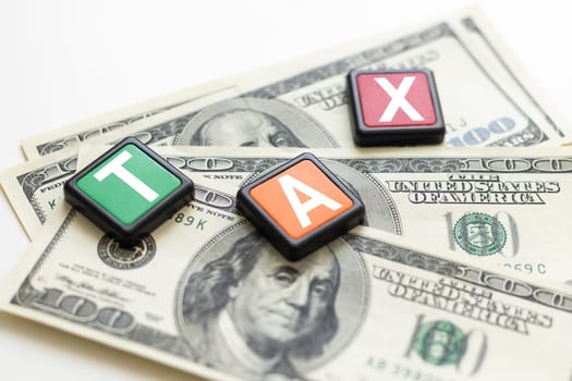 word TAX on wooden cubes, grey background, business concept. High quality photo