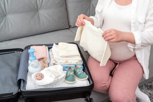 Woman in late pregnancy packing things for maternity hospital.