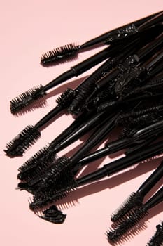 Black eyelash brushes on a pink background. Women's cosmetics. Face Makeup.