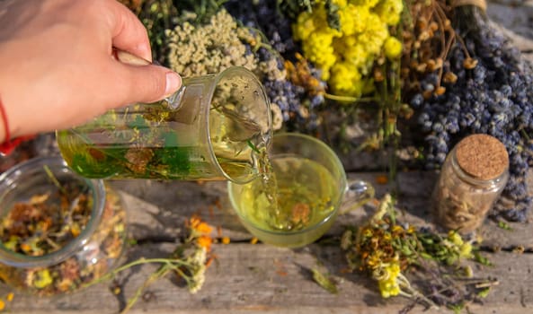 A woman brews herbal tea. Selective focus. Nature.