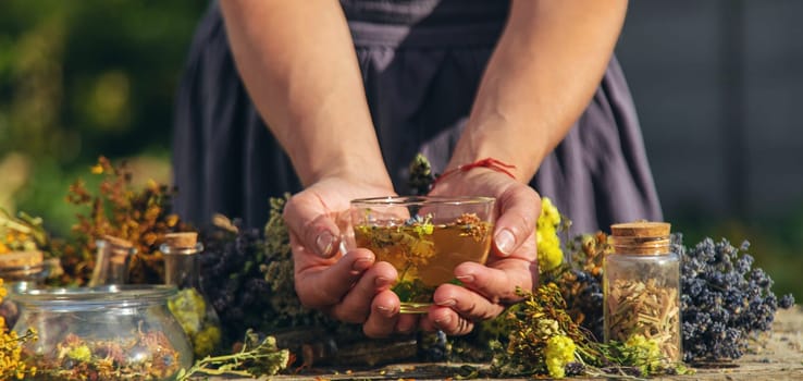 A woman brews herbal tea. Selective focus. Nature.