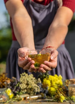 A woman brews herbal tea. Selective focus. Nature.