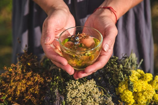 A woman brews herbal tea. Selective focus. Nature.