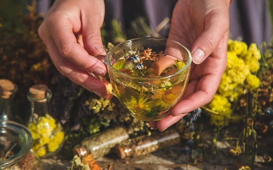 A woman brews herbal tea. Selective focus. Nature.