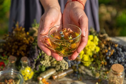 A woman brews herbal tea. Selective focus. Nature.