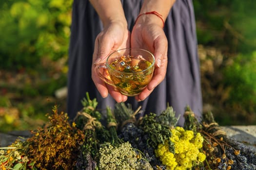 A woman brews herbal tea. Selective focus. Nature.