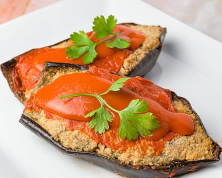 Stuffed eggplant with red sauce and parsley on a white plate, typical food, typical mediterranean mallorcan cuisine typical from balearic islands mallorca, spain,