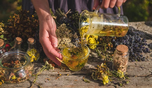 A woman brews herbal tea. Selective focus. Nature.