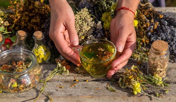 A woman brews herbal tea. Selective focus. Nature.