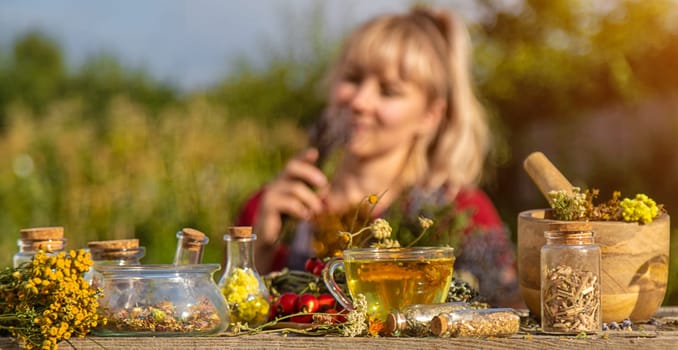 A woman brews herbal tea. Selective focus. Nature.