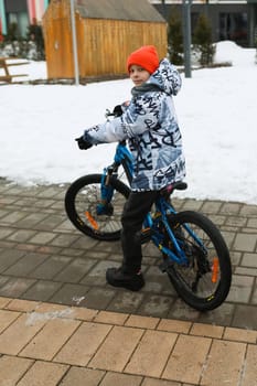 Boy riding a bike during winter holidays.