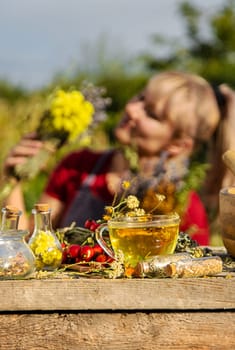 A woman brews herbal tea. Selective focus. Nature.