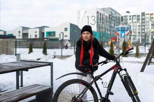 Lifestyle concept, Caucasian woman frolicking while riding a bicycle in winter.