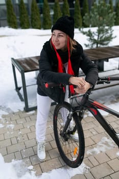 European woman in winter clothes riding a bicycle in winter.