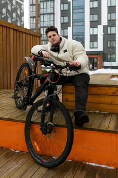 Young European man spends active time with a bicycle.