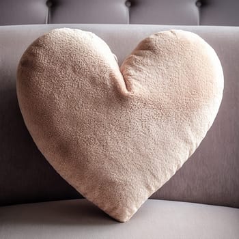 Plush heart-shaped pillow on a gray couch.