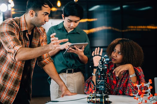 A group of students and teacher in a classroom studying on a robotic arm. Encouraging innovation teamwork and skill-building in educational settings. Robot hand. Innovation and technology concept