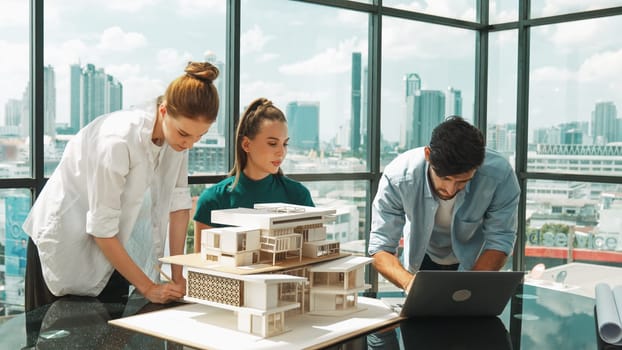 Smart architect team discussion about house design while handsome male worker present idea by using laptop. Group of professional engineer sharing, brainstorming design. Business design. Tracery