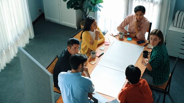 Top view of manager standing and present idea at whiteboard. Group of diverse people listen presentation while making a decision for investment. Team looking at leader talking about plan. Convocation.