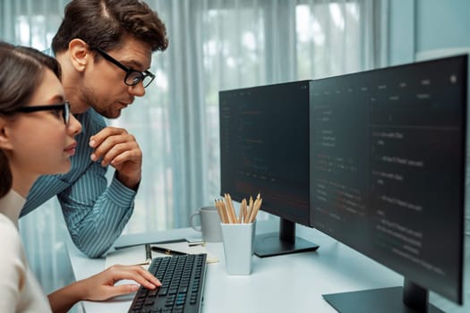 Team skilled developers program thinking newest coding creative website planning software project on two pc screen, comparing with typing full stack data analyzing prompt design at office. Postulate.