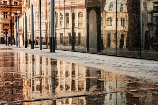 Reflection of classical architecture on a wet city sidewalk.