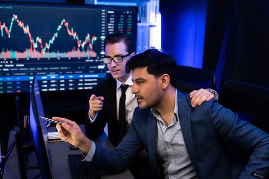 Two stock exchange traders getting profit in trading currency stock. Successful stock exchange showing financial benefit data on monitor screen at highest point of neon light at workplace. Sellable.