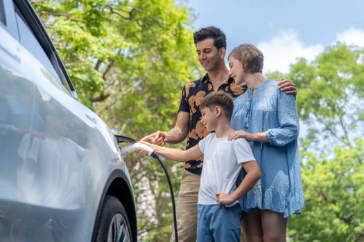 Family road trip vacation with electric vehicle, lovely family recharge EV car with green and clean energy. Natural and eco friendly car travel for sustainable environment. Perpetual