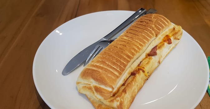 Grilled smoked beef mushroom Panini or sandwich served with white plate on the wooden table, in a famous restaurant