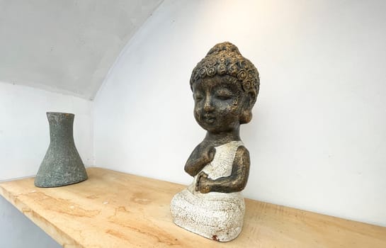 Small statue decorations for table and interior, little buddha statue modern simplistic house environment with several pottery and wooden table