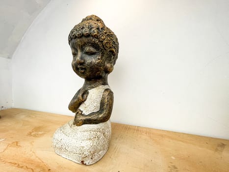 Small statue decorations for table and interior, little buddha statue modern simplistic house environment with several pottery and wooden table